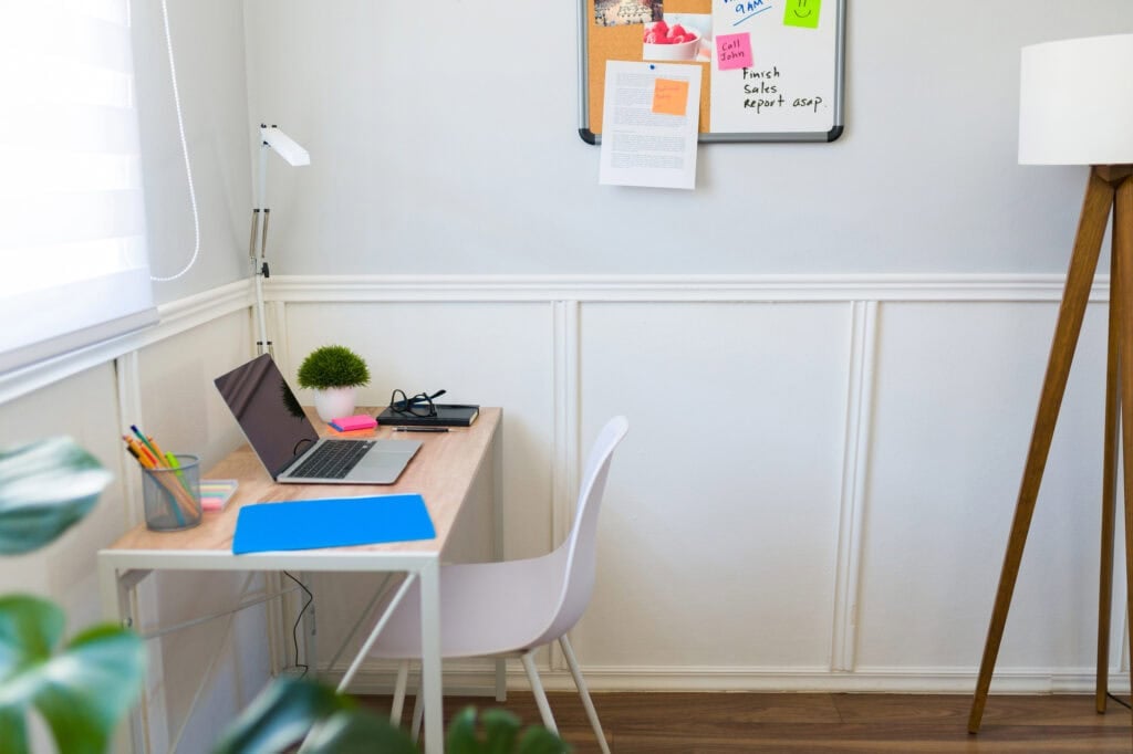 Relaxing office desk with a laptop, lamp, sticky notes for article on how to make $7000 a month
